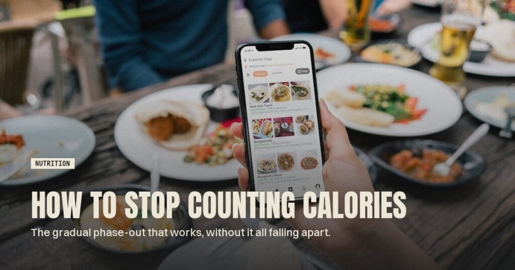 Hand holding a smartphone showing a food app at a table of dishes